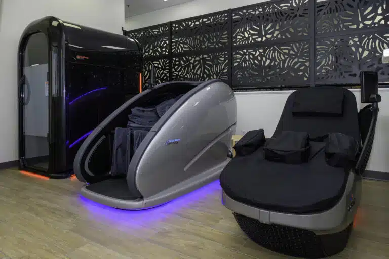 RallyWell Wellness Recovery Club amenities: infrared sauna pod, cold-plunge pod, and massage chair