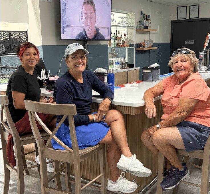 Three women seated together at the RallyWell bar